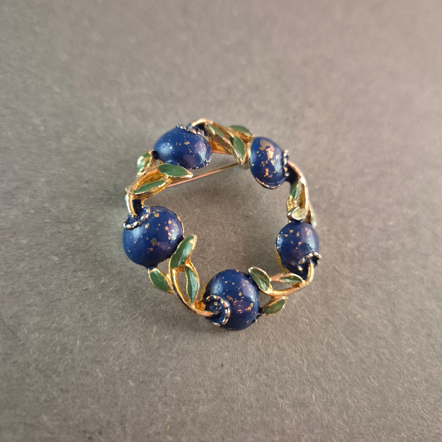 Vintage-Brosche mit blauen Emaille-Beeren und goldfarbenem Blätterkranz