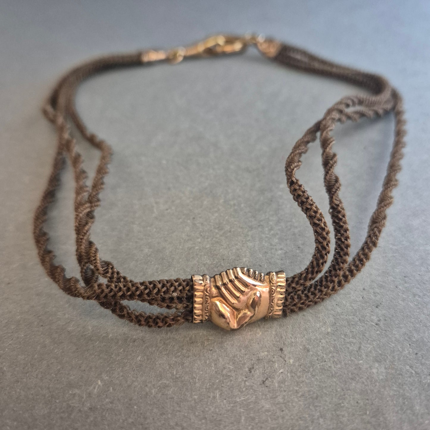 Vintage Textilhalskette mit goldfarbenem Handsymbol – Filigrane Eleganz