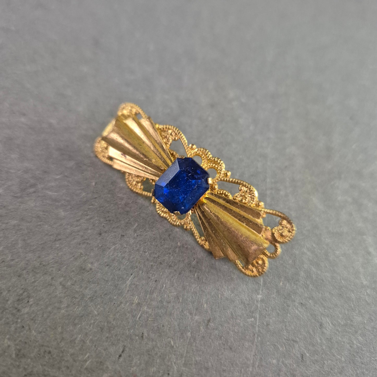 Goldfarbene Vintage-Brosche mit blauem Stein – Filigrane Eleganz