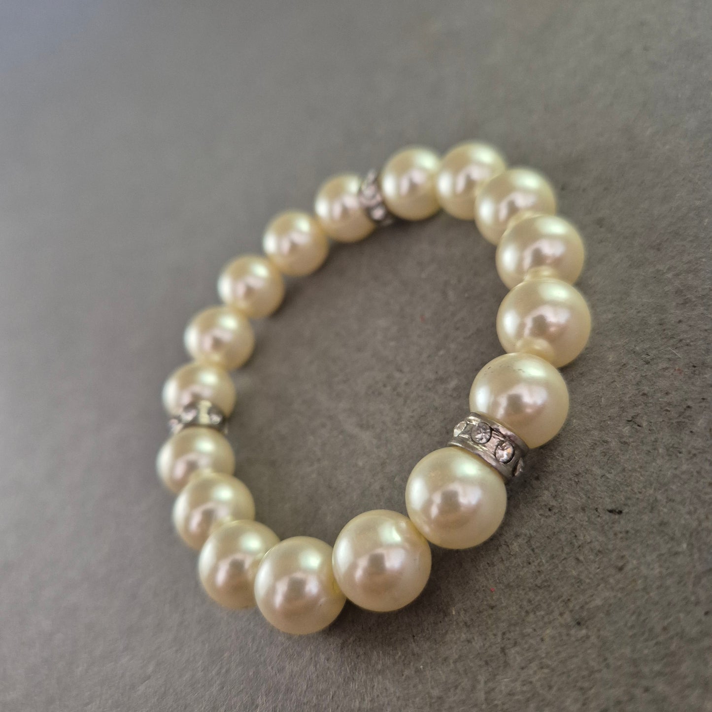 Elastisches Armband mit Perlenoptik & Strassringen – Klassisch elegant