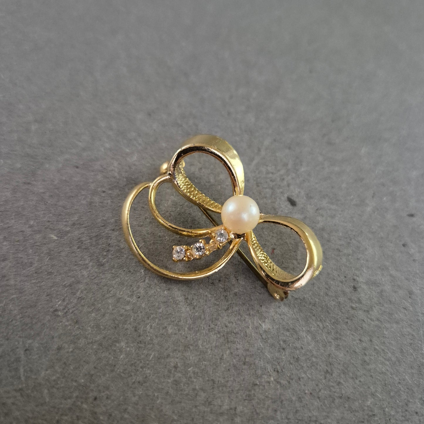 Zarte Brosche in Schleifenform mit Strass und Perlenimitat