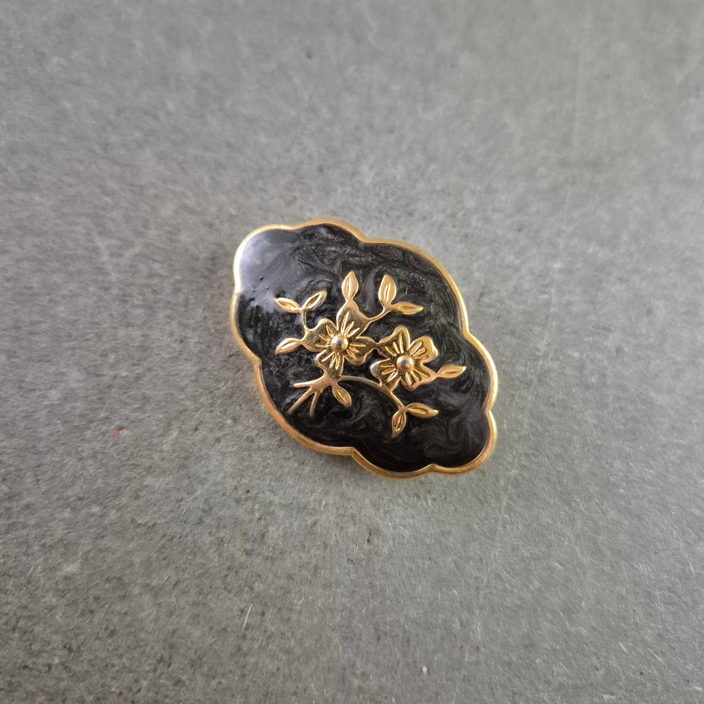 Elegante Brosche in Schwarz-Gold mit Blumenmotiv