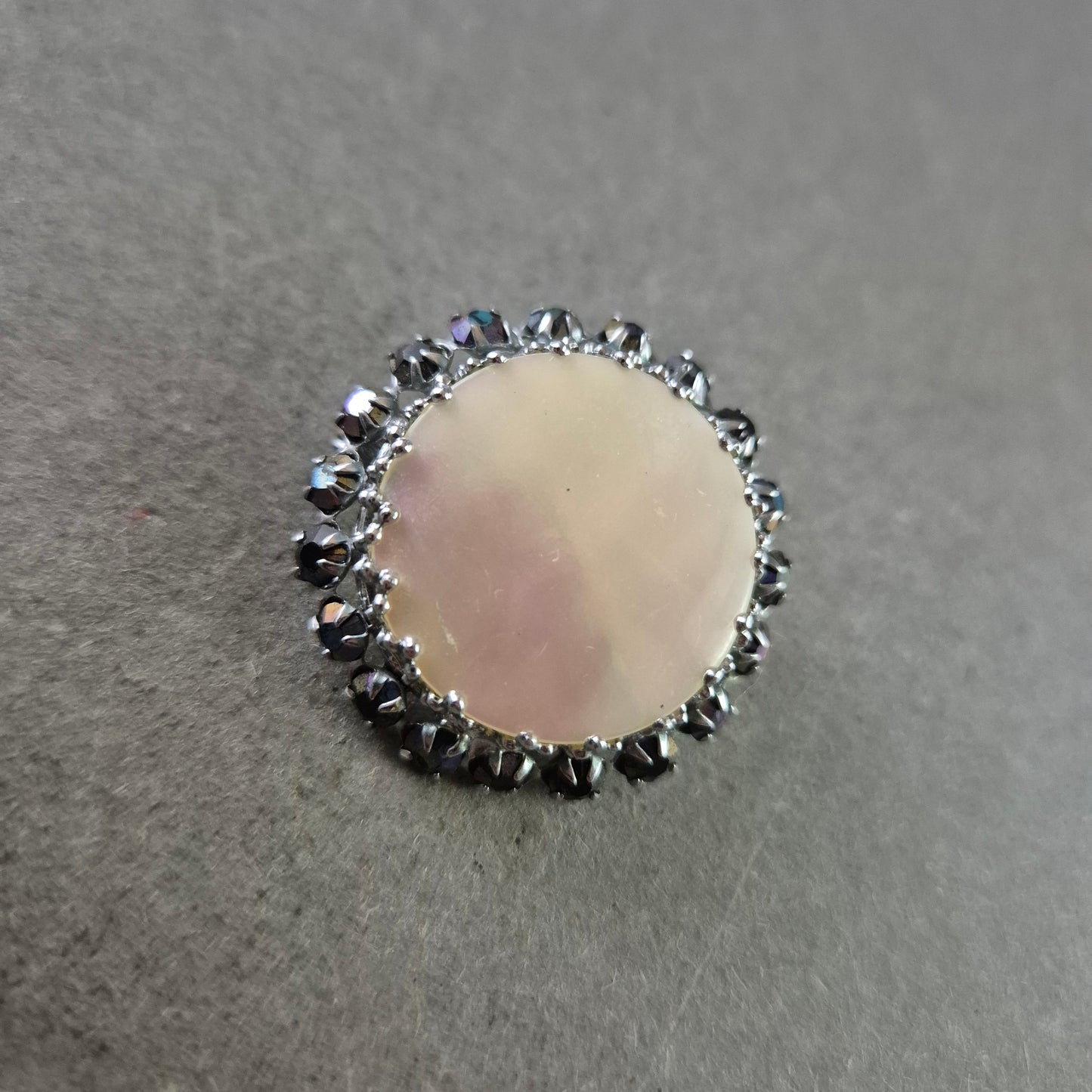 Runde Brosche mit Perlmutt und schwarzer Steinverzierung