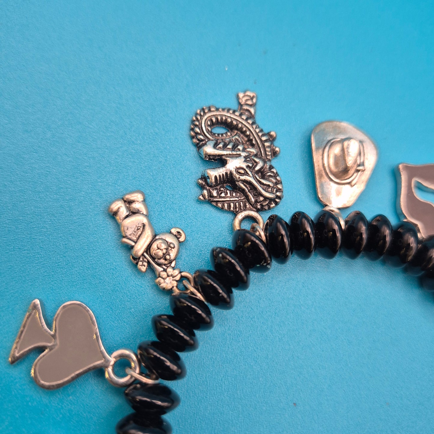 Verspieltes Vintage Charm-Armband mit schwarzen Perlen und Anhängern