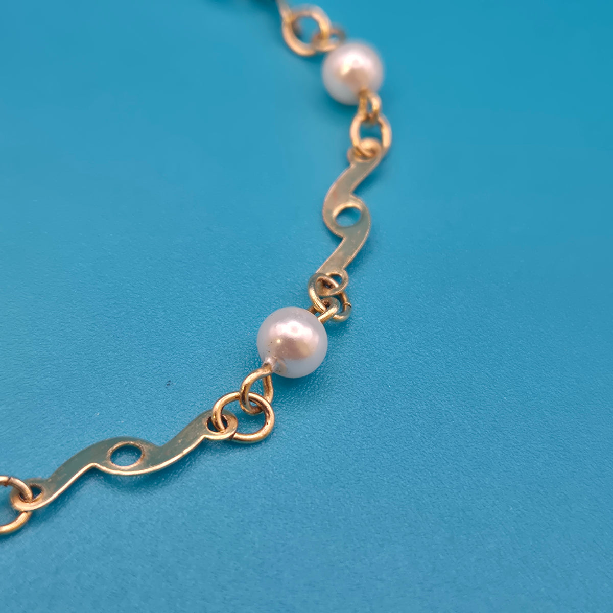 Elegantes Vintage-Armband mit Ziergliedern und weißen Perlen Goldfarben