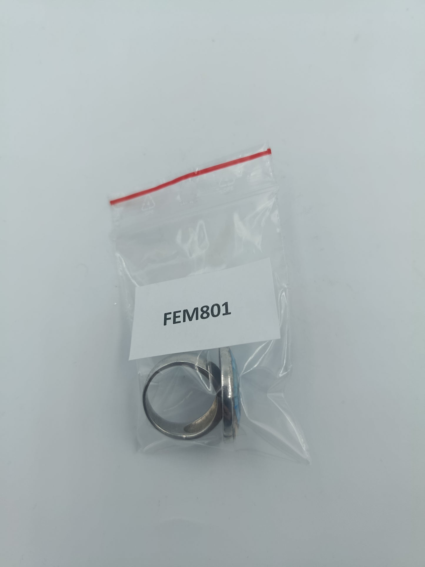 Silberfarbener Mosaikring mit blauer Spirale