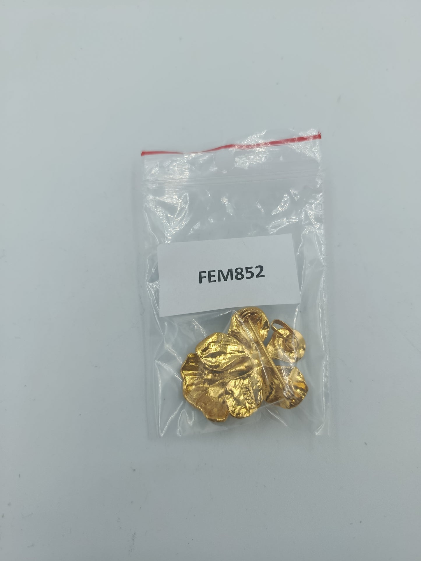 Goldfarbene Blütenbrosche mit schwarzer Emaille