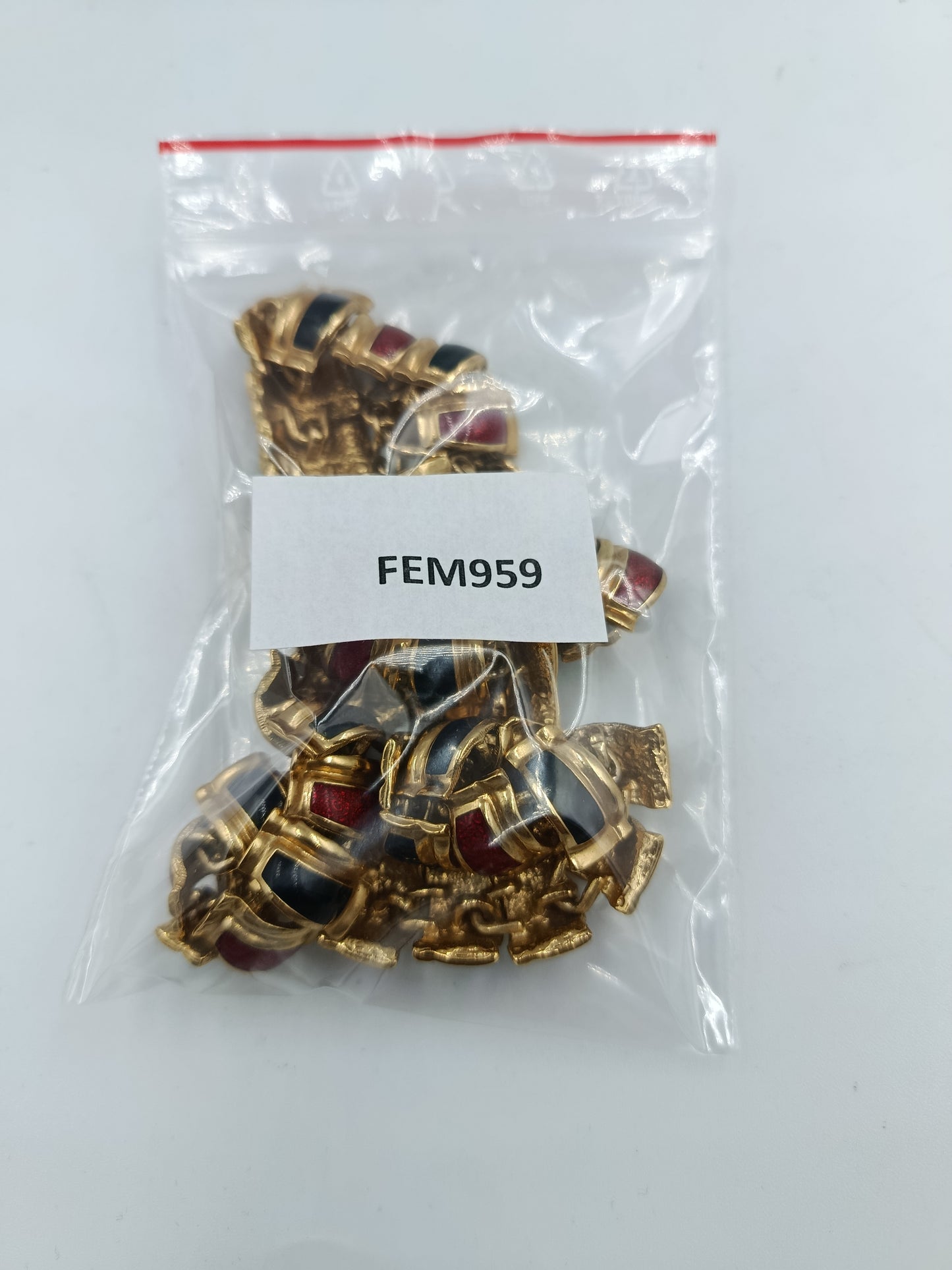 Halskette mit goldfarbenen Gliedern und rot schwarzen Emaille Elementen