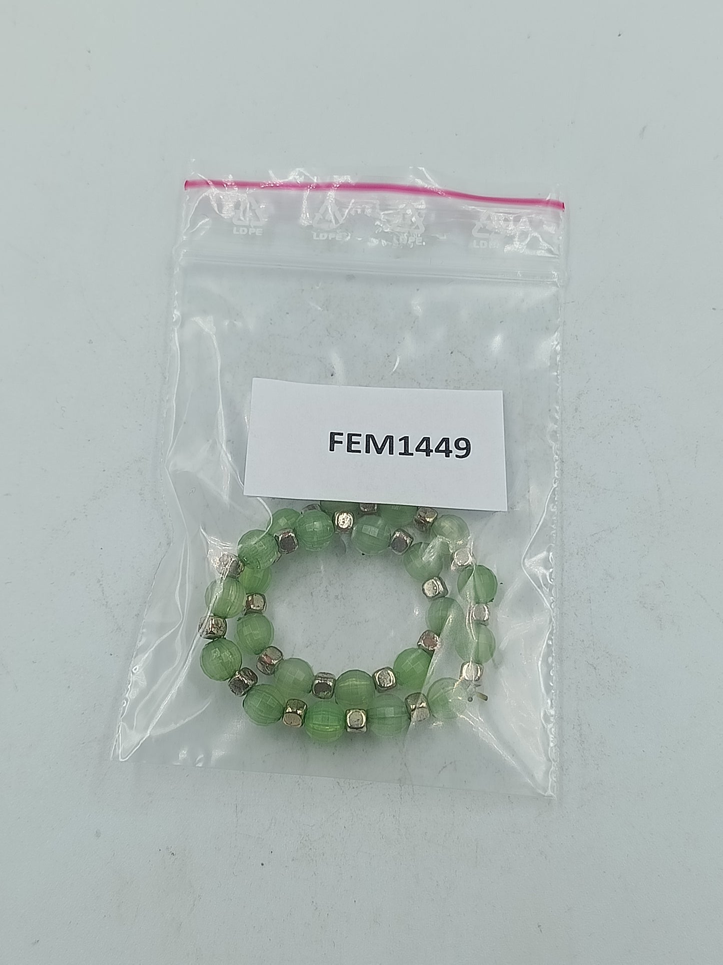 Elastisches Armband mit grünen facettierten Perlen und silberfarbener Optik