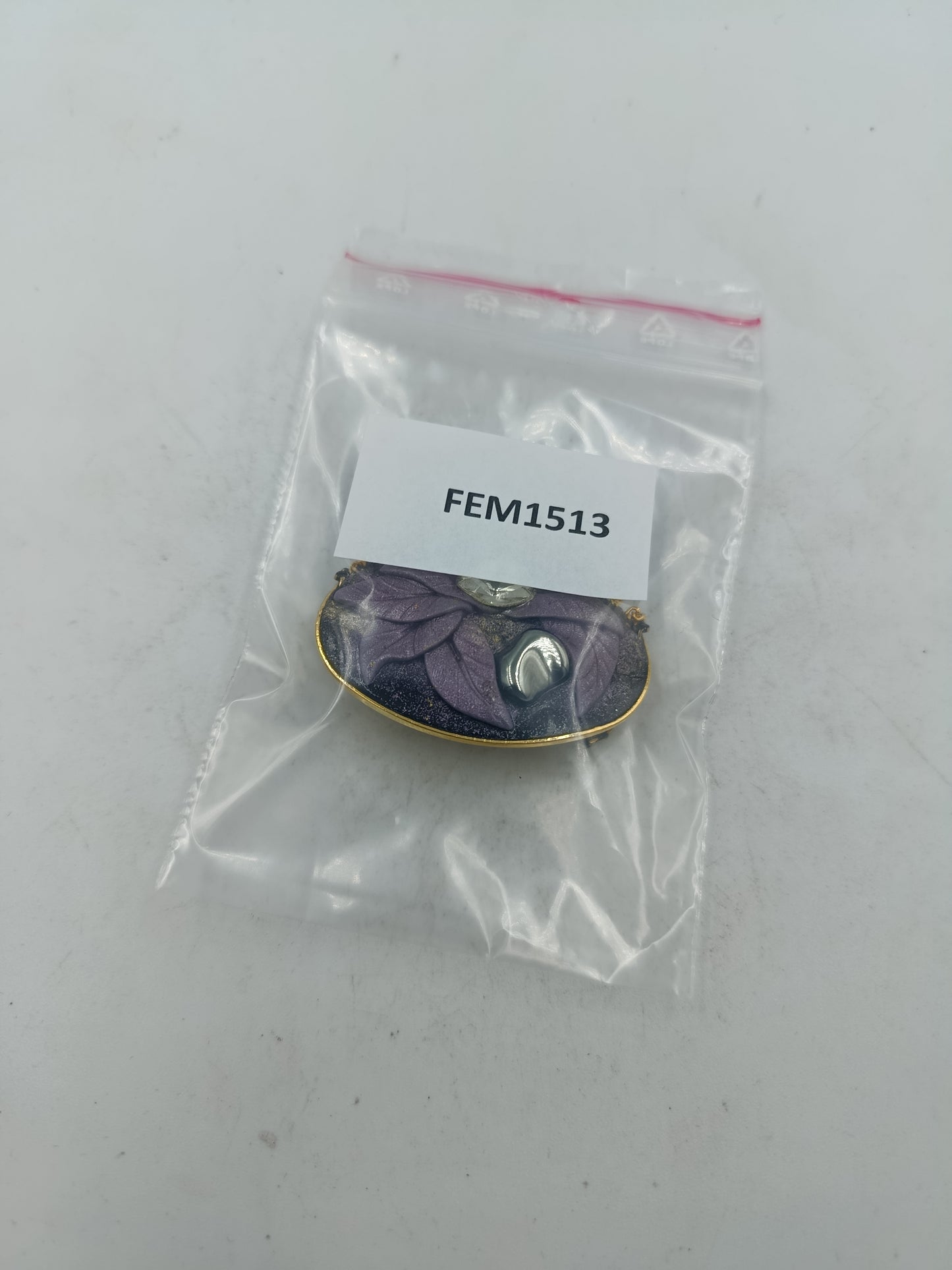 Ovale Brosche mit violettem Blattmotiv und goldfarbenen Zierketten