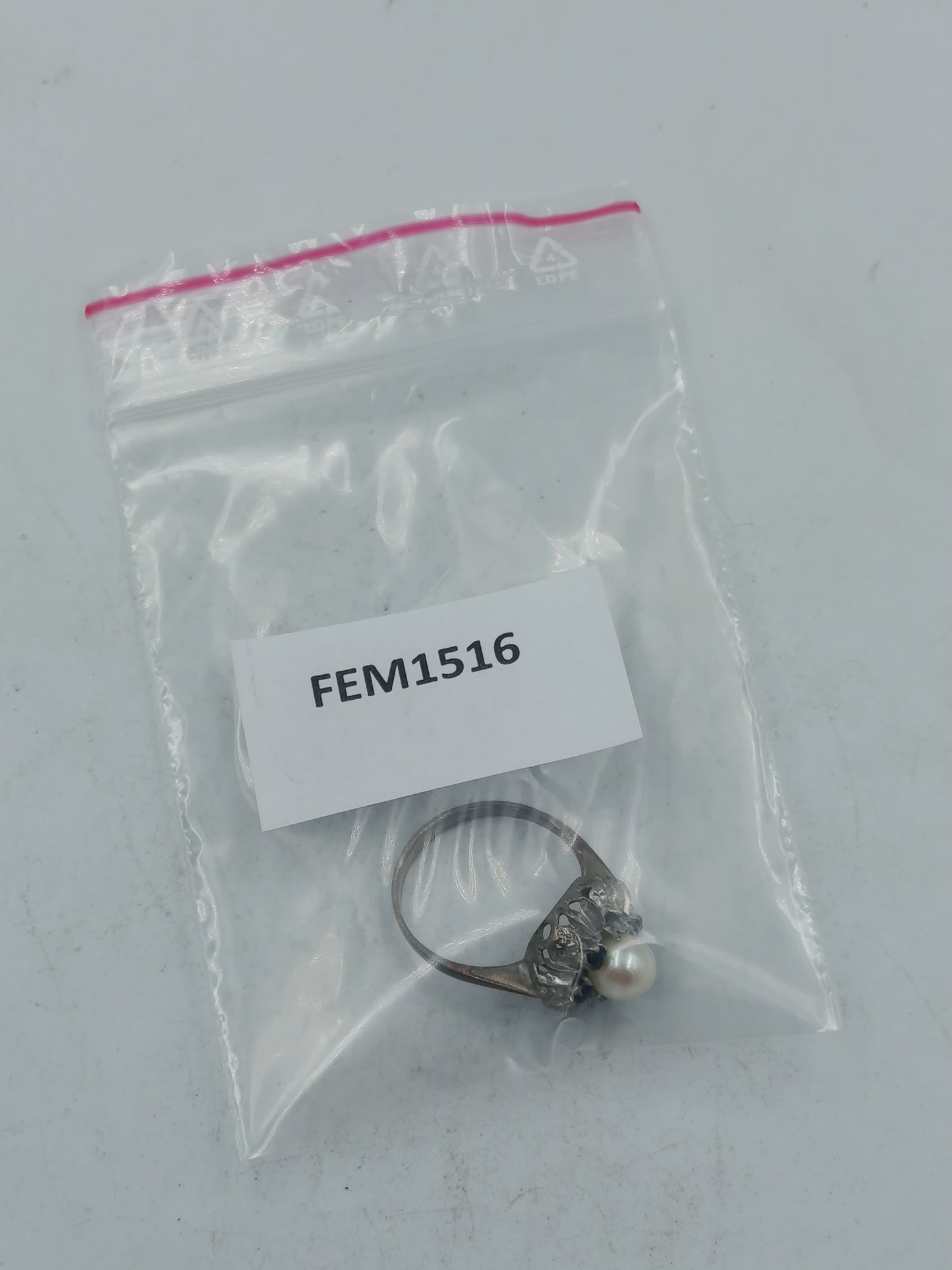 Perlenring mit dunkelblauen Steinen und kunstvoller silberfarbener Fassung im klassischen Stil