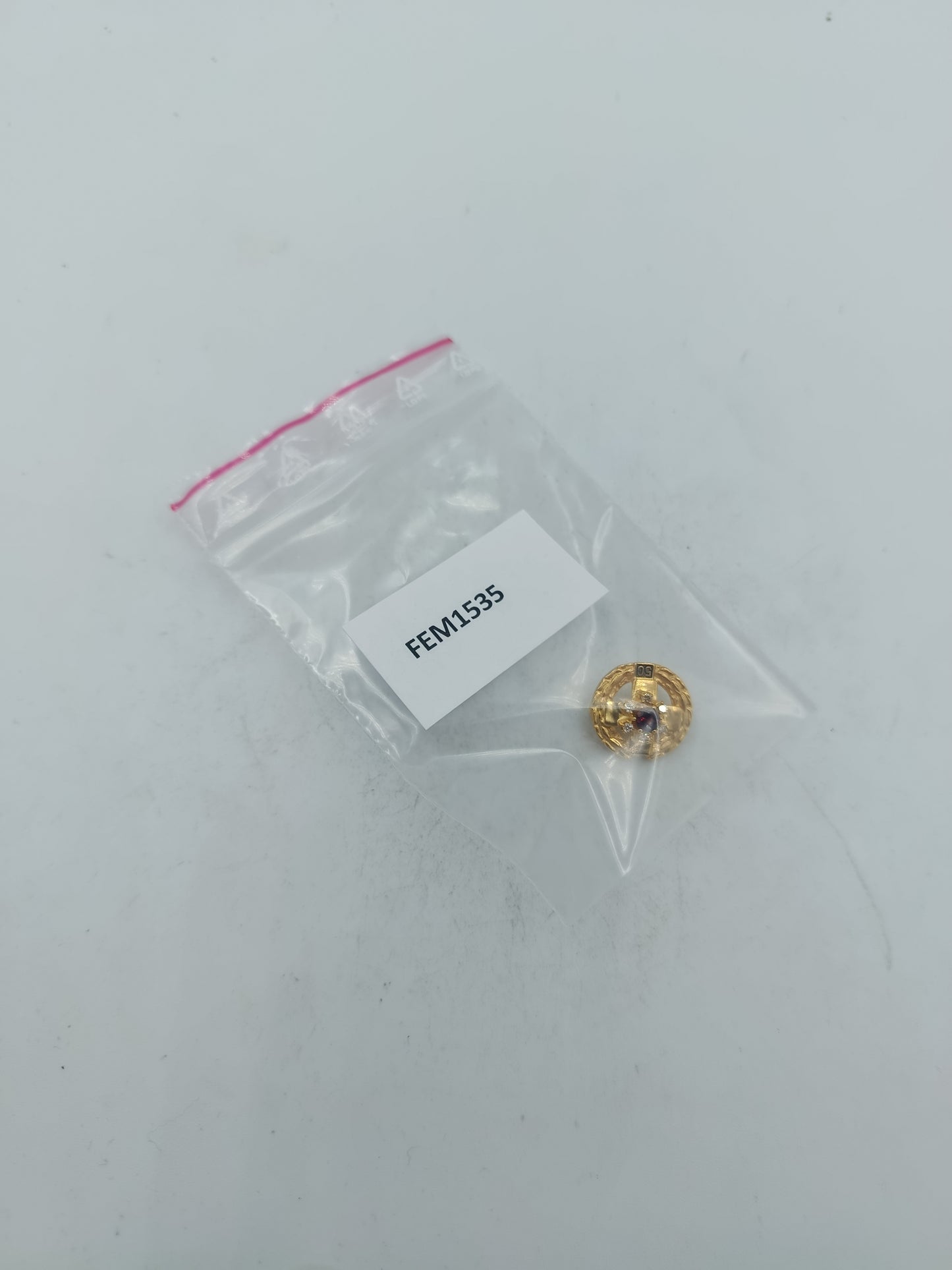 Goldfarbene Brosche mit rotem Mittelstein und funkelnden Akzenten im klassischen Stil