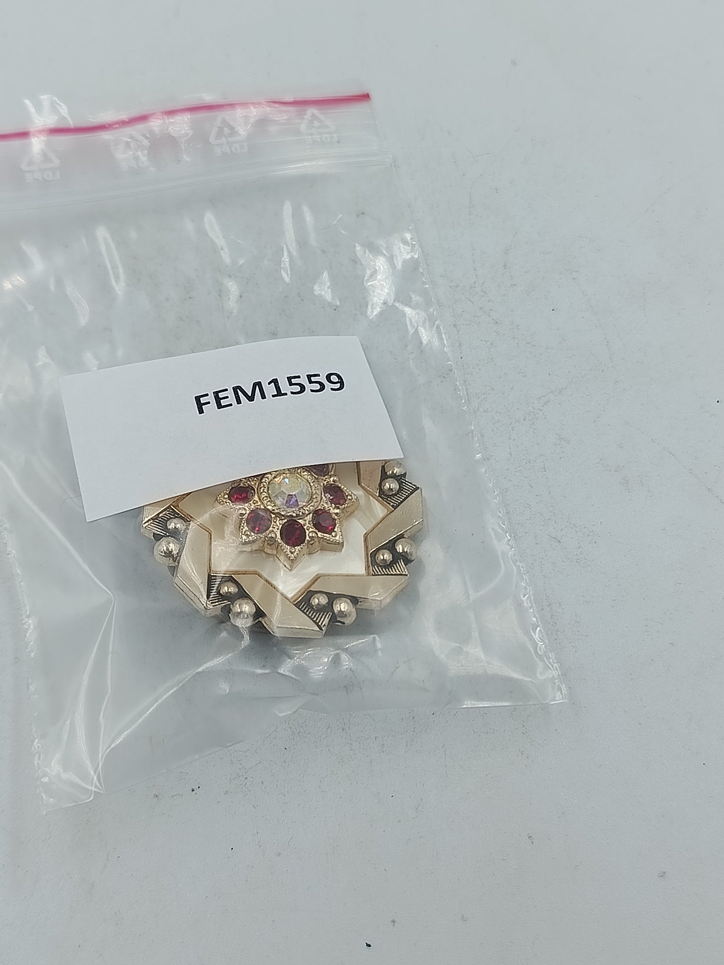 Cilpper in Goldoptik mit rotem Steindesign und Akzent für ausdrucksstarke Eleganz