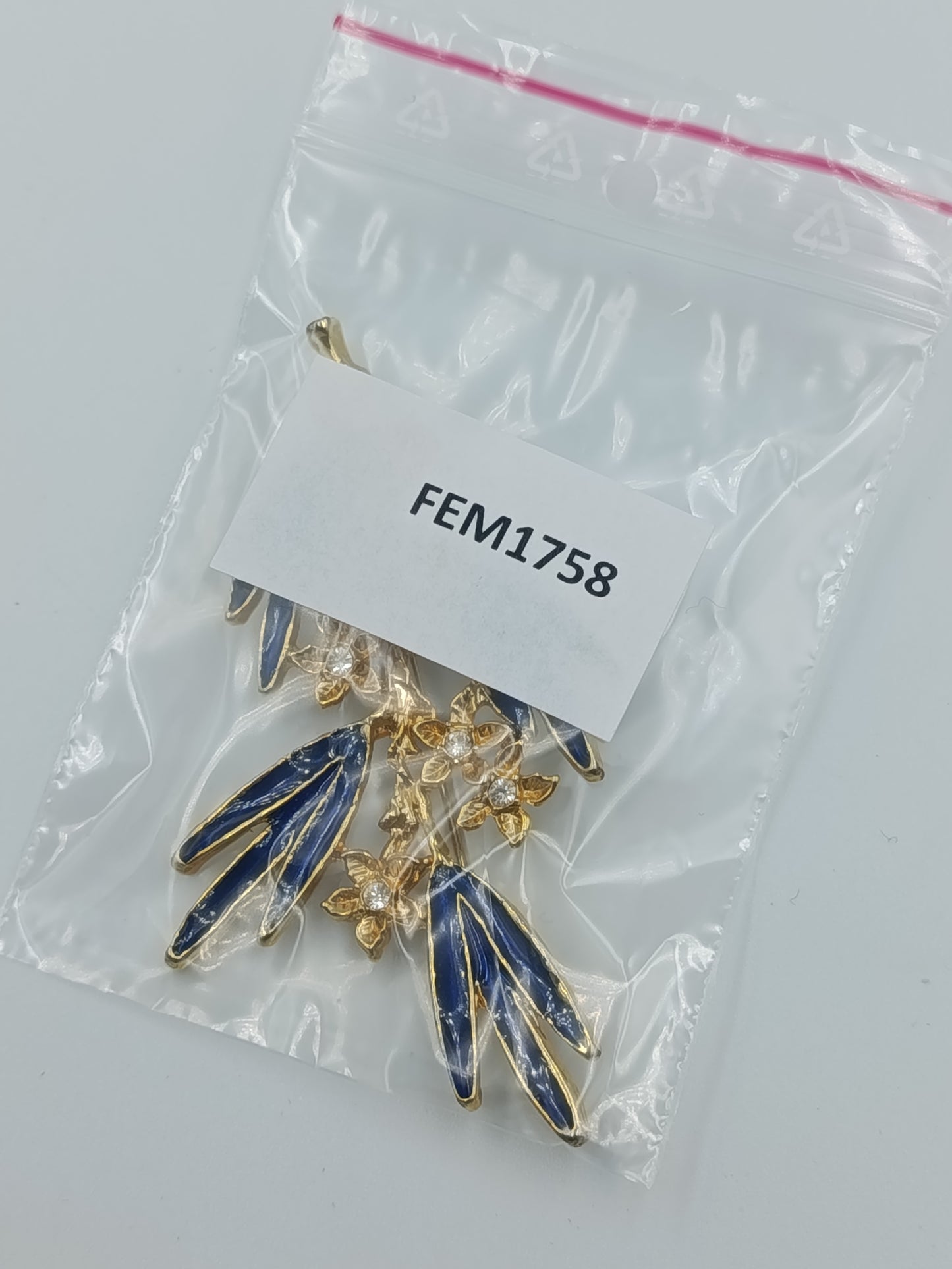 Elegante Brosche mit blauen Emailleblättern und funkelnden Blüten in Goldoptik