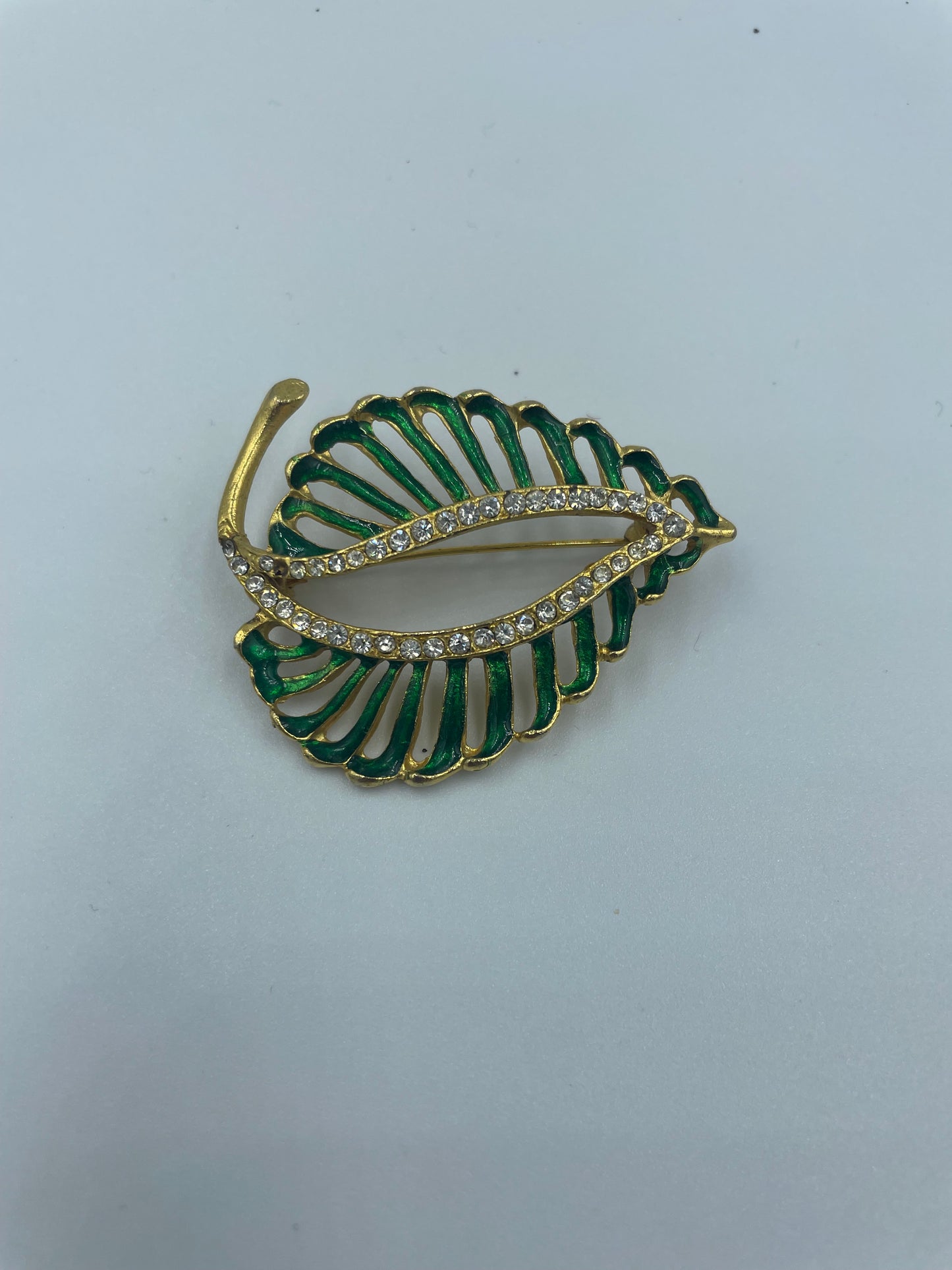 Vergoldete Brosche mit funkelnden kleinen Steinen