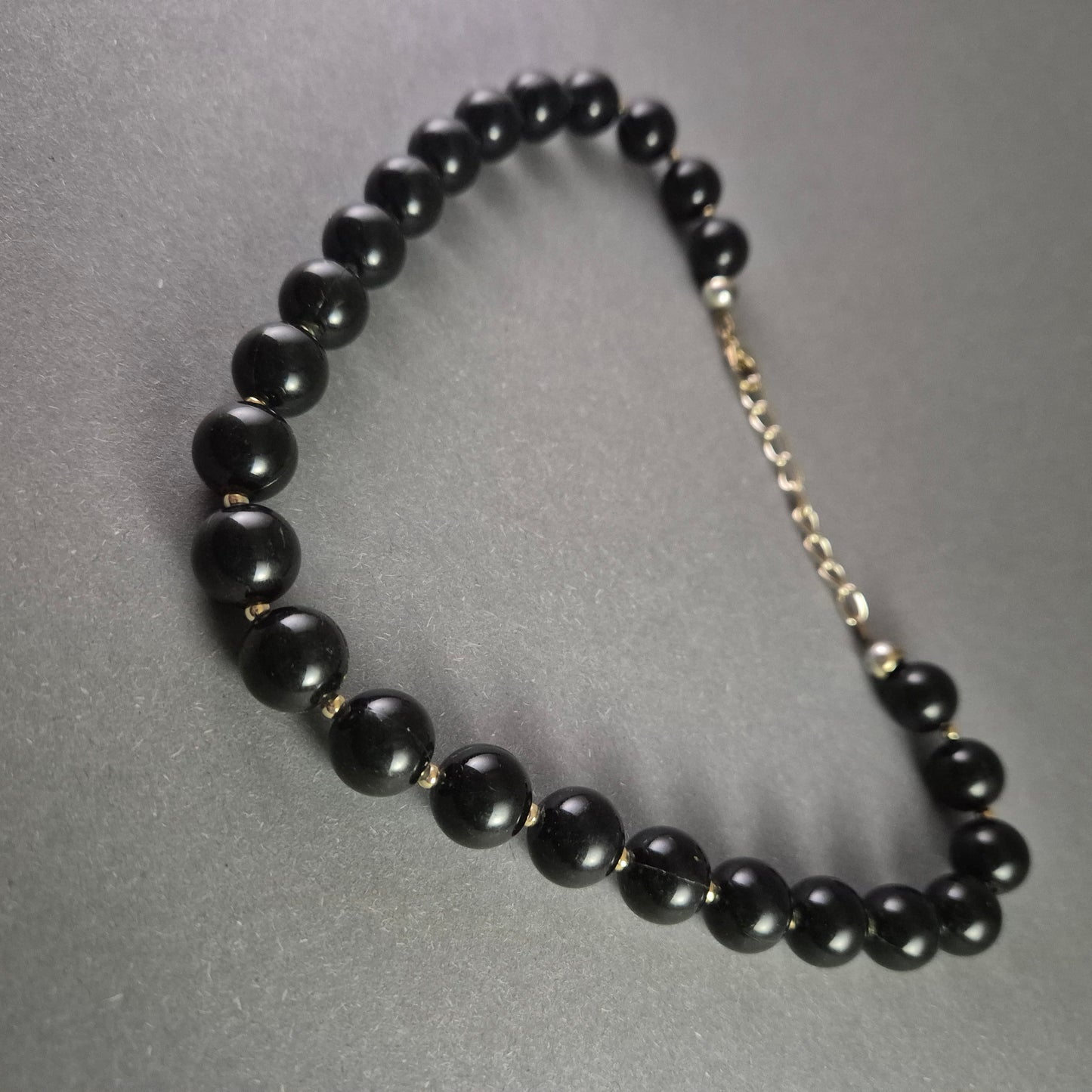 Klassische Perlenkette – Elegante schwarze Kugelperlen mit Goldakzenten