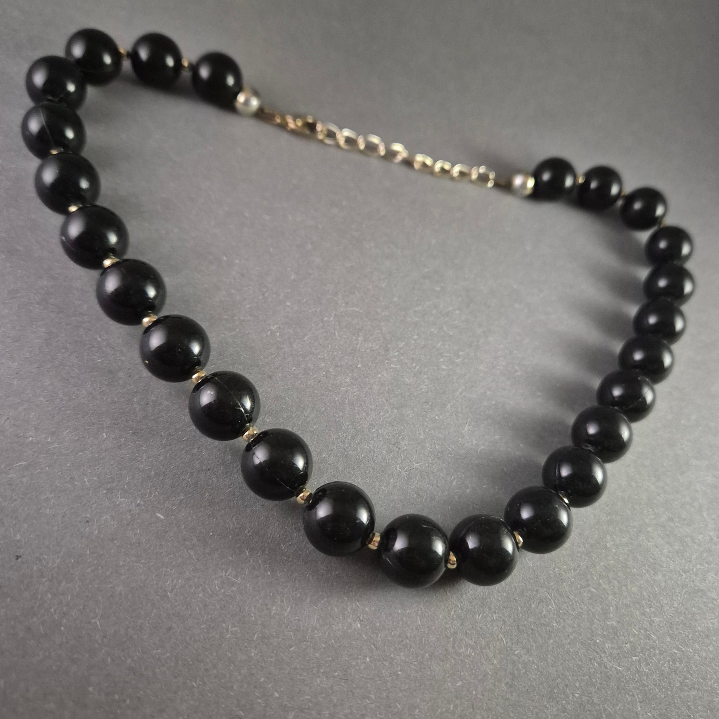 Klassische Perlenkette – Elegante schwarze Kugelperlen mit Goldakzenten