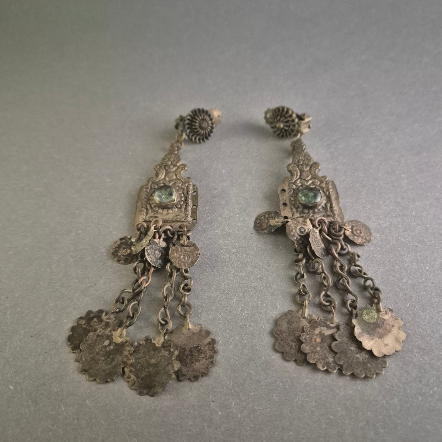 Antike Silberohrringe mit grünen Steinen und filigranem Münzdesign