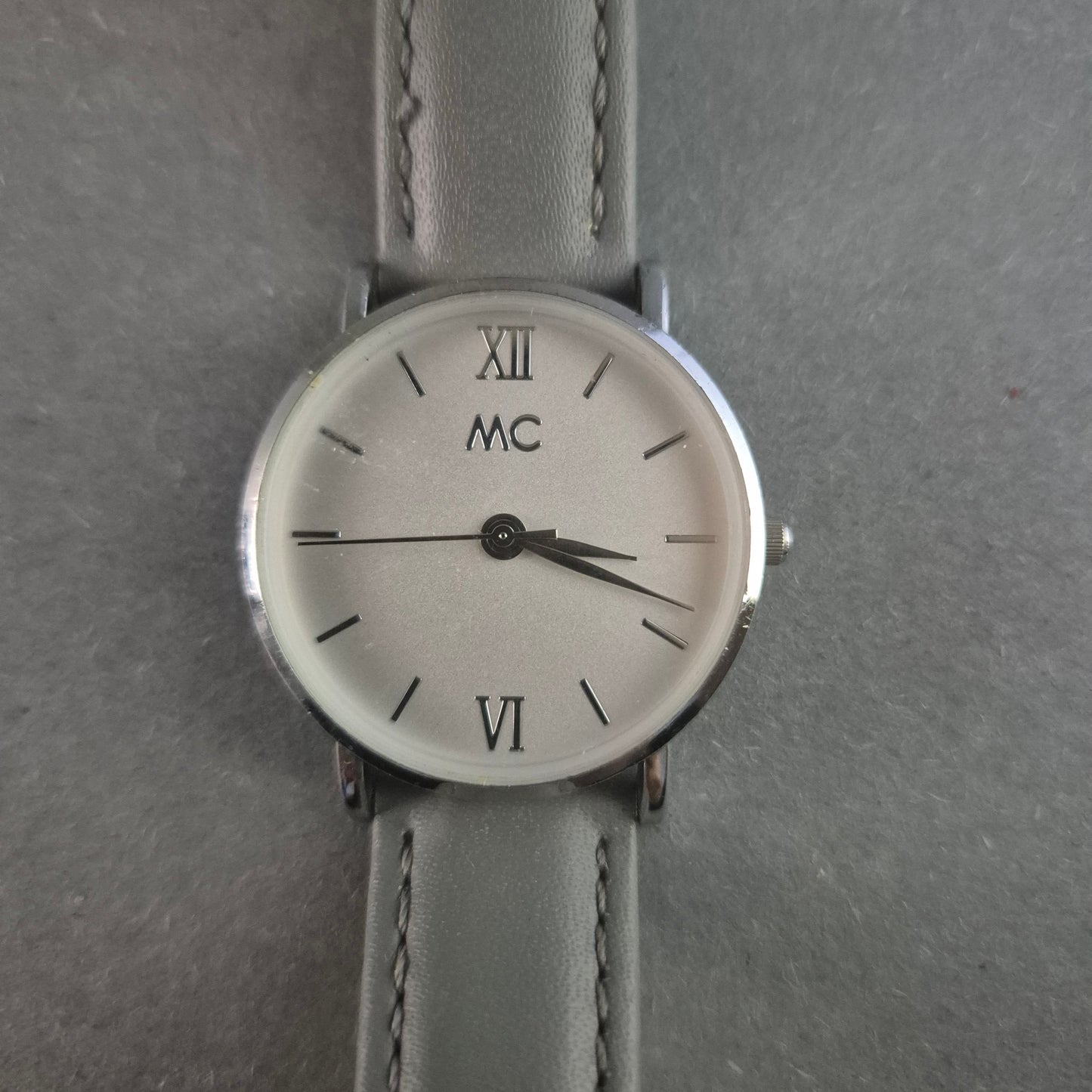 Elegante MC Armbanduhr – Minimalistisches Design mit grauem Lederarmband