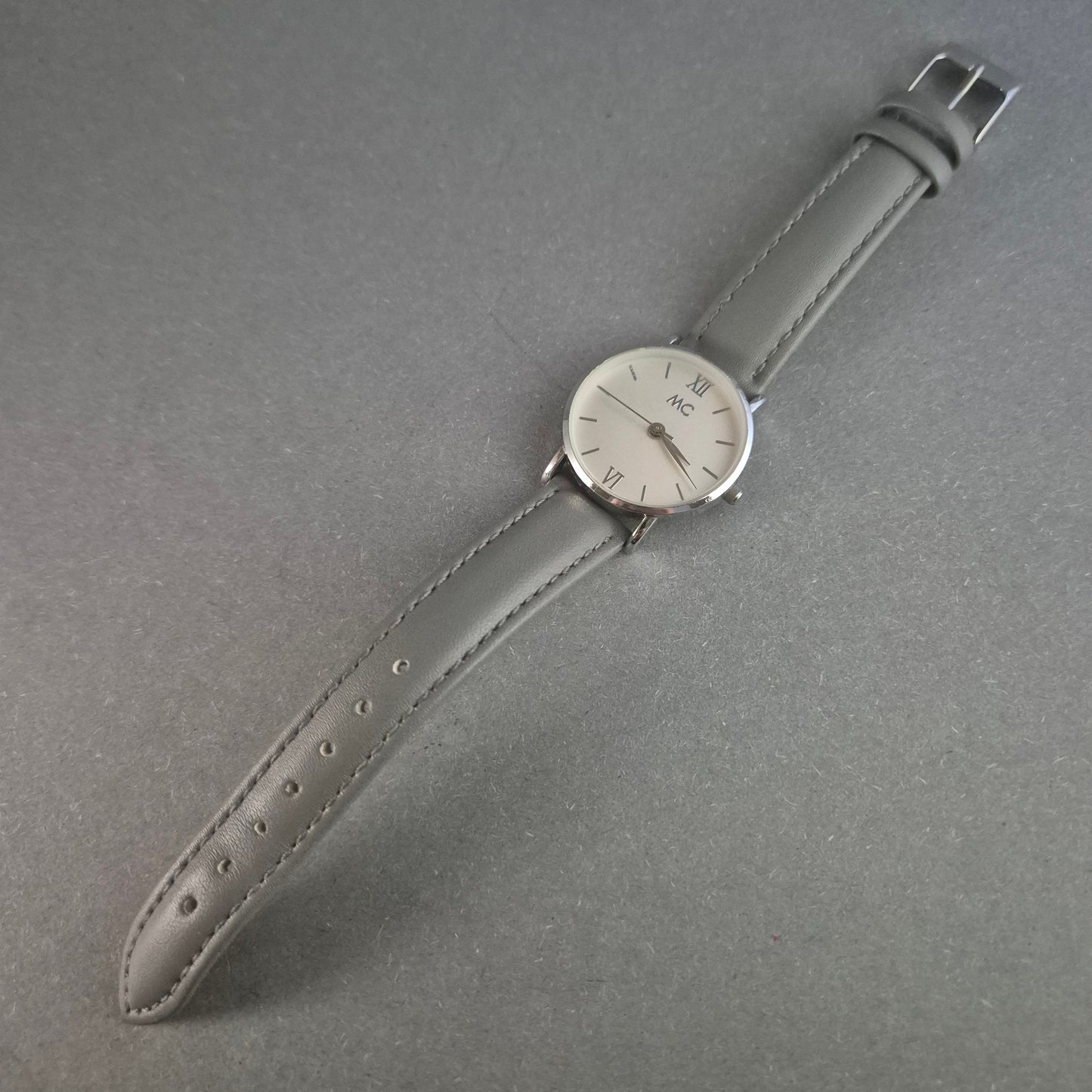 Elegante MC Armbanduhr – Minimalistisches Design mit grauem Lederarmband