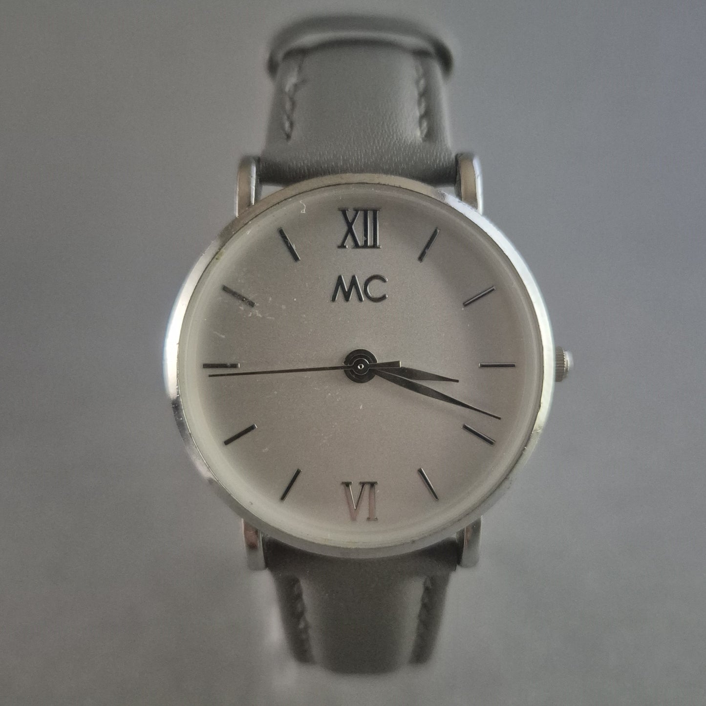 Elegante MC Armbanduhr – Minimalistisches Design mit grauem Lederarmband