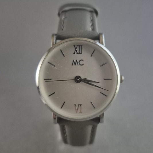 Elegante MC Armbanduhr – Minimalistisches Design mit grauem Lederarmband
