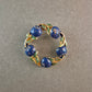 Vintage-Brosche mit blauen Emaille-Beeren und goldfarbenem Blätterkranz