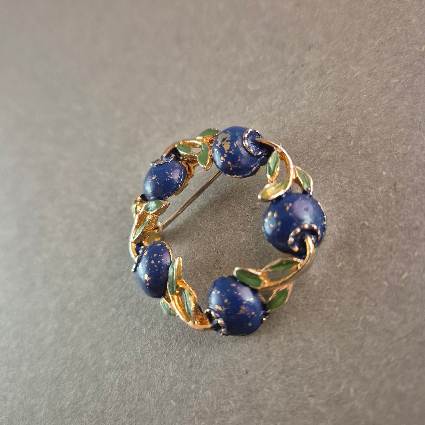 Vintage-Brosche mit blauen Emaille-Beeren und goldfarbenem Blätterkranz