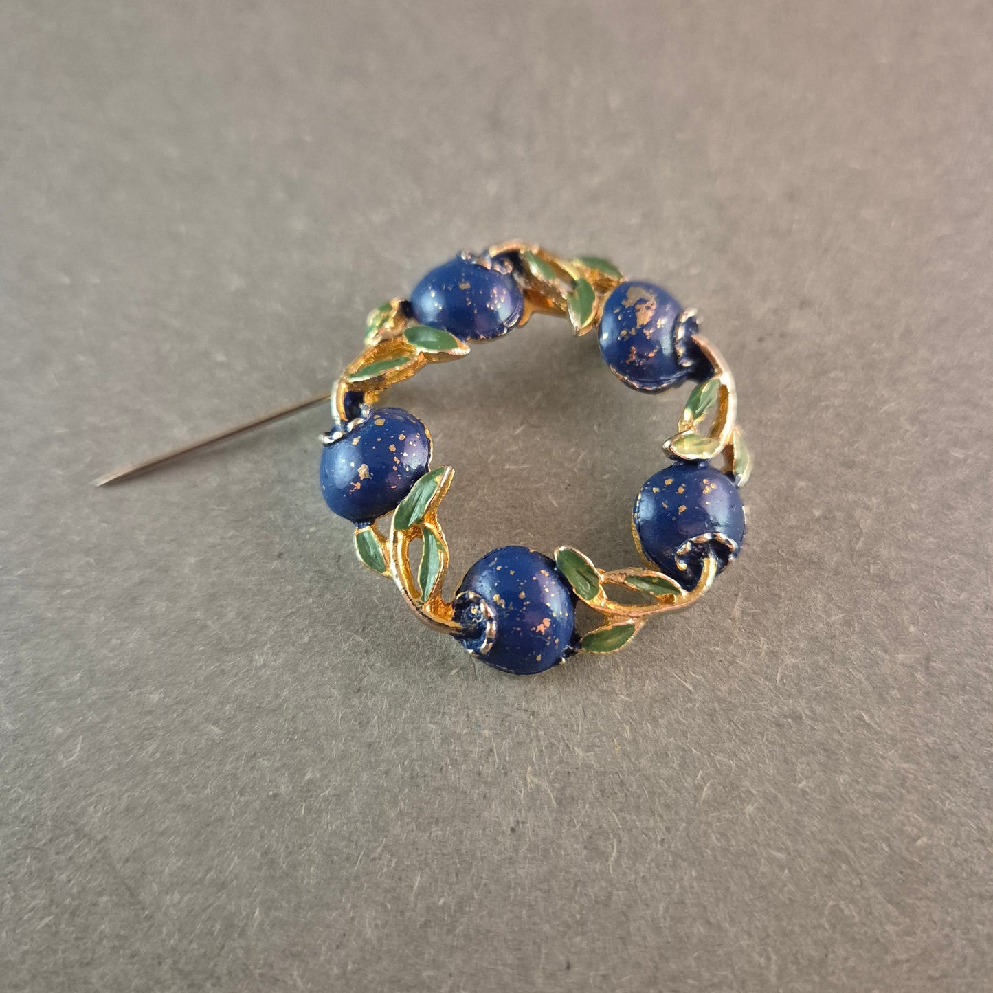 Vintage-Brosche mit blauen Emaille-Beeren und goldfarbenem Blätterkranz