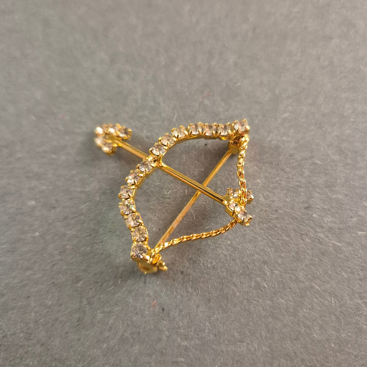 Goldene Brosche Pfeil und Bogen mit funkelnden Strasssteinen