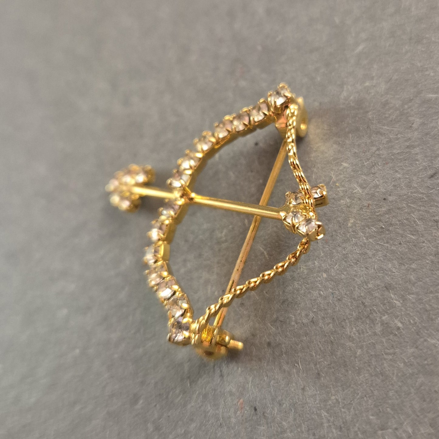 Goldene Brosche Pfeil und Bogen mit funkelnden Strasssteinen