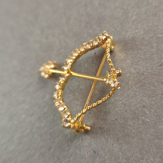 Goldene Brosche Pfeil und Bogen mit funkelnden Strasssteinen
