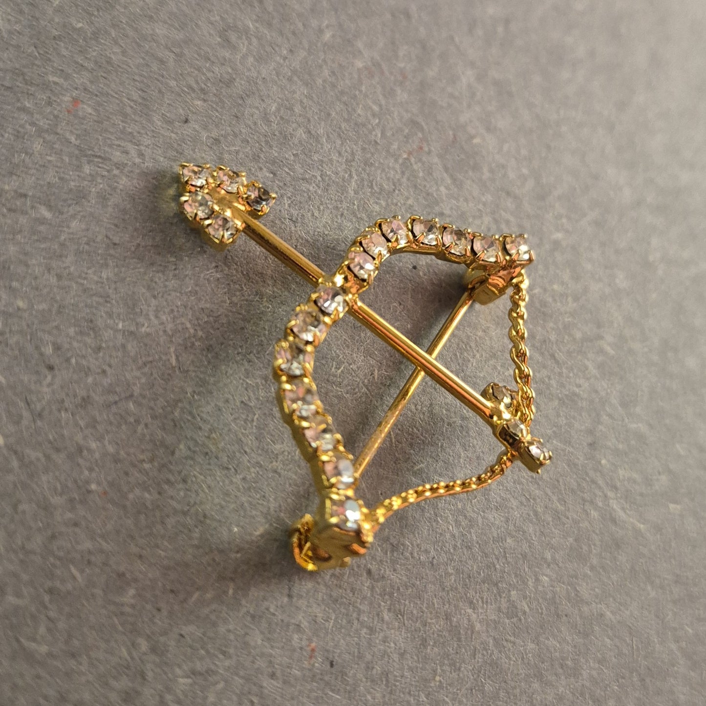 Goldene Brosche Pfeil und Bogen mit funkelnden Strasssteinen