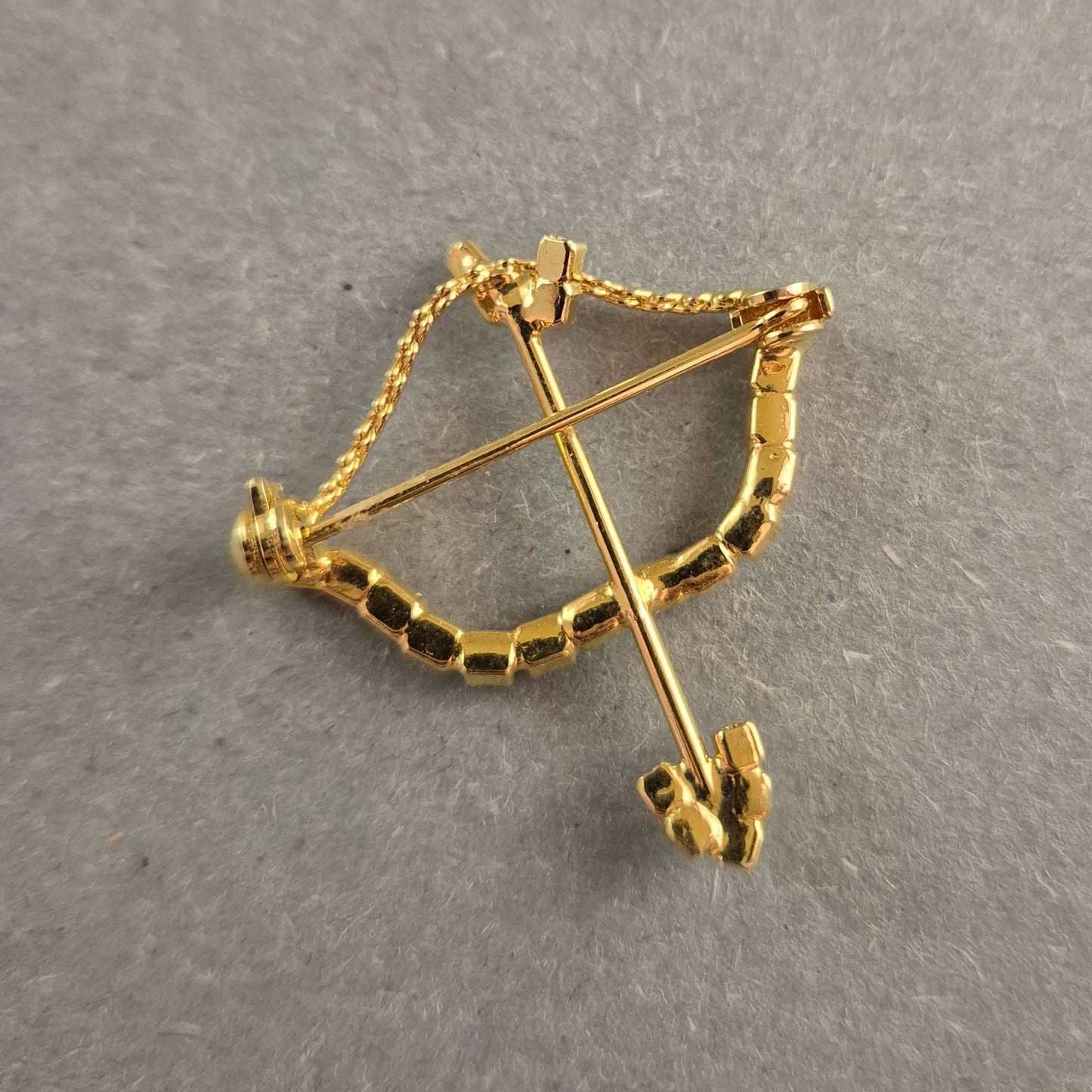 Goldene Brosche Pfeil und Bogen mit funkelnden Strasssteinen