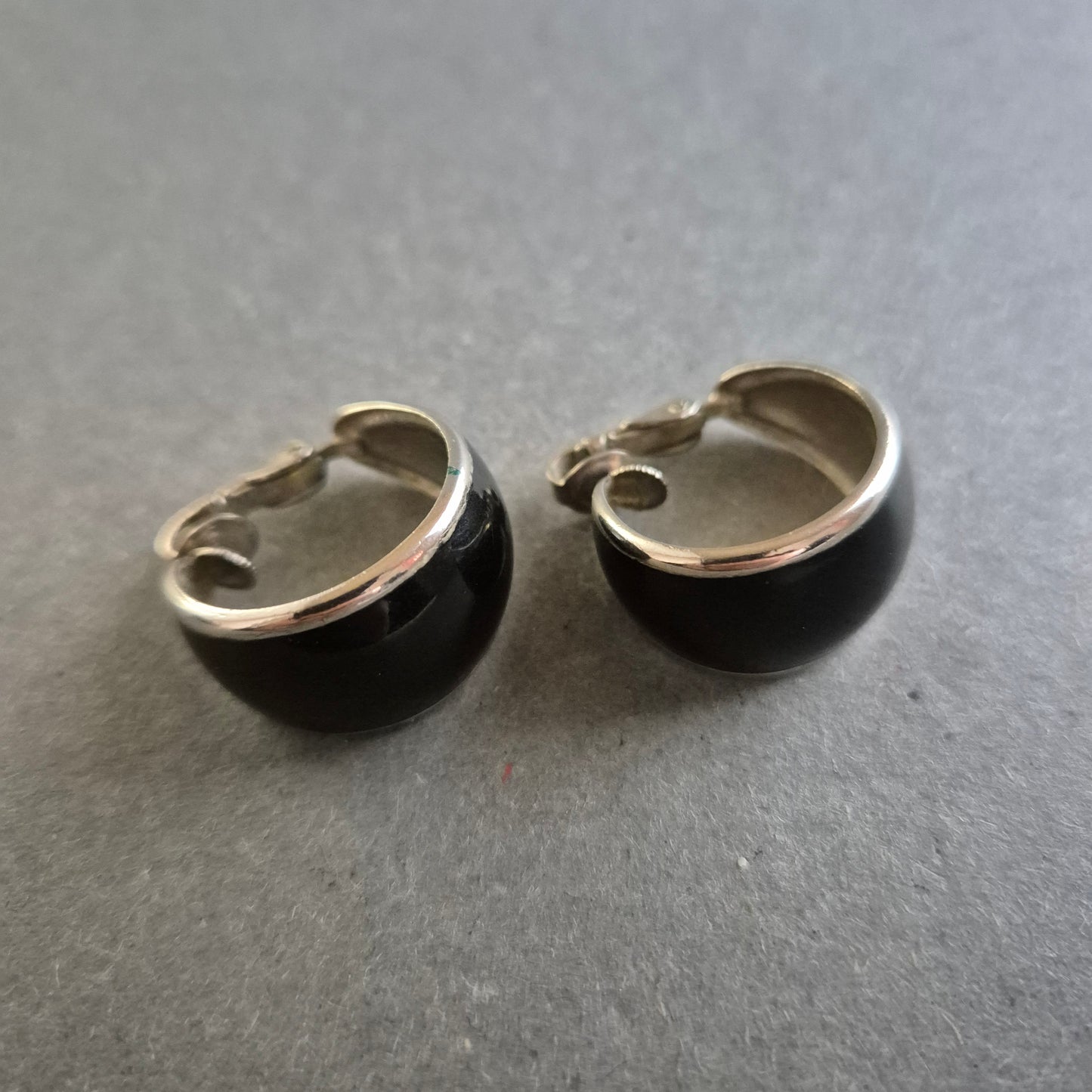 Klassische schwarze Clip-Ohrringe mit silberfarbenem Rand