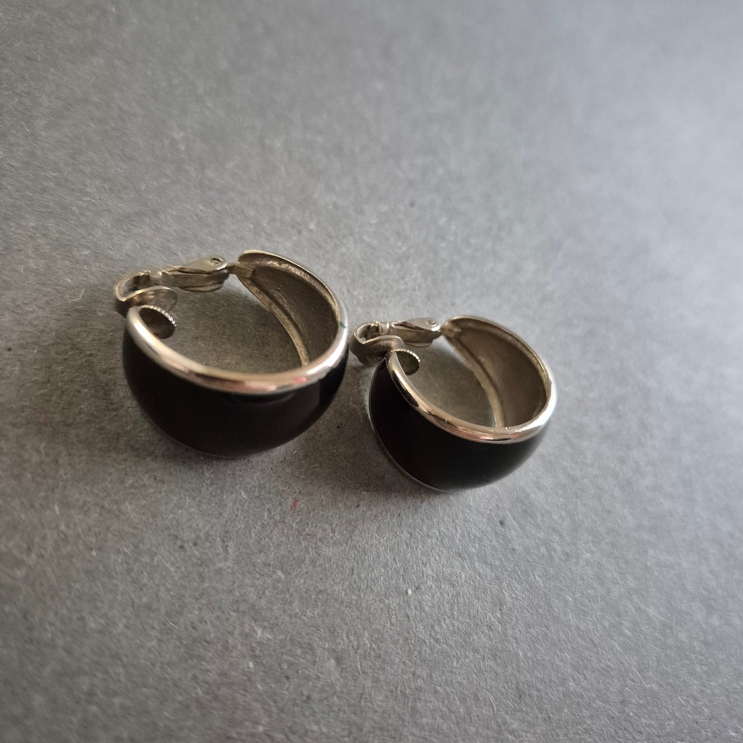 Klassische schwarze Clip-Ohrringe mit silberfarbenem Rand