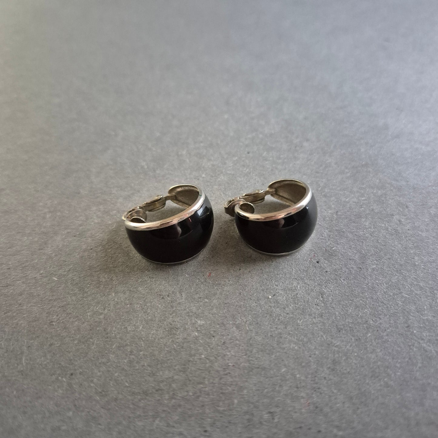 Klassische schwarze Clip-Ohrringe mit silberfarbenem Rand