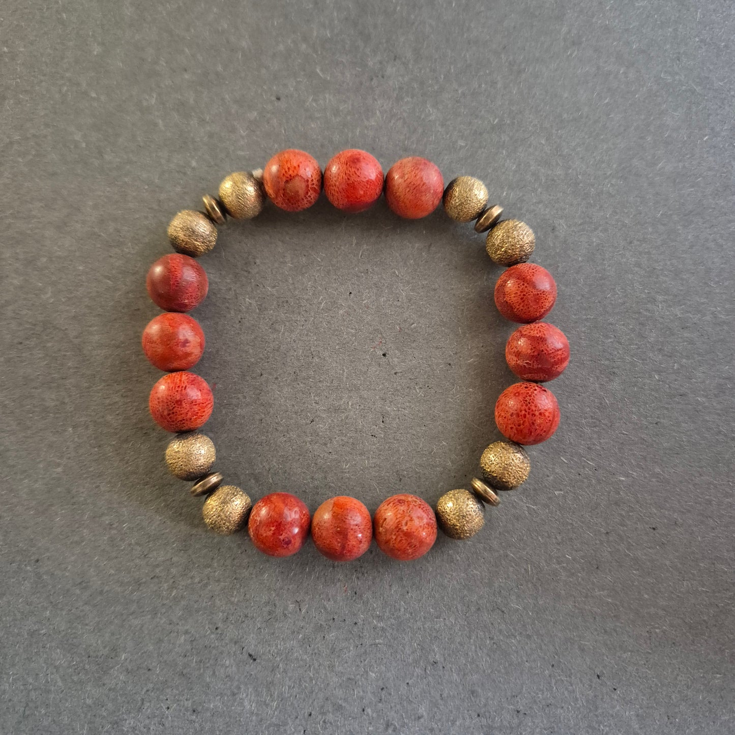 Elastisches Armband mit roten Steinperlen & goldfarbenen Akzenten