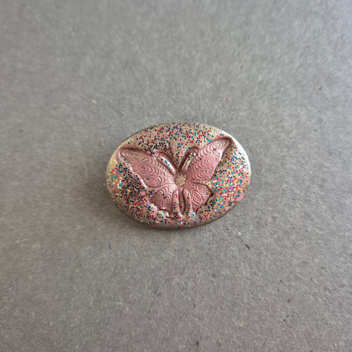 Ovale Glitzer-Brosche – Mit rosa Schmetterling