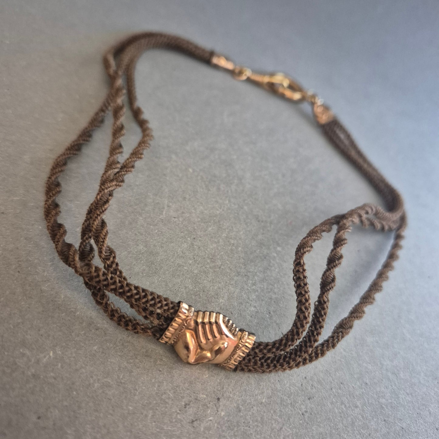 Vintage Textilhalskette mit goldfarbenem Handsymbol – Filigrane Eleganz