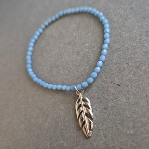 Zartes Perlenarmband in Hellblau mit Federanhänger – Boho trifft Minimalismus