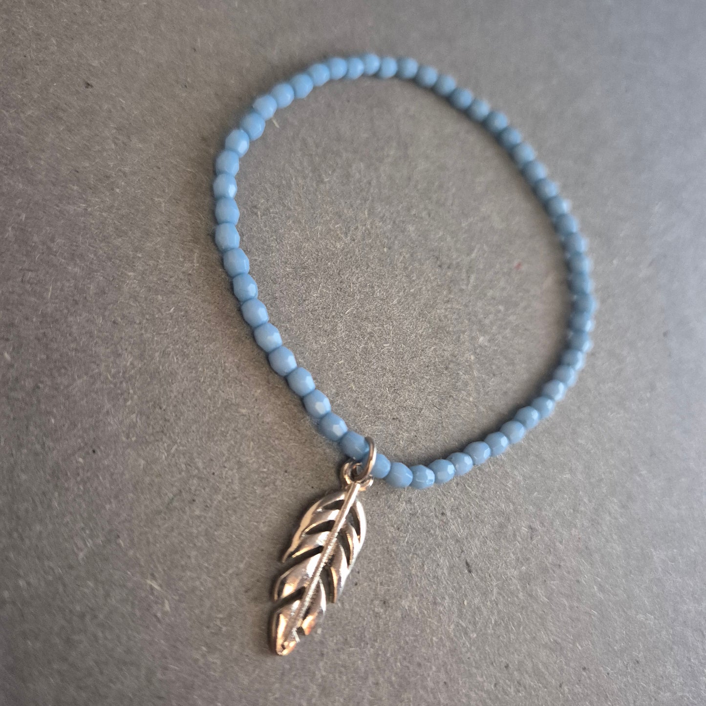 Zartes Perlenarmband in Hellblau mit Federanhänger – Boho trifft Minimalismus
