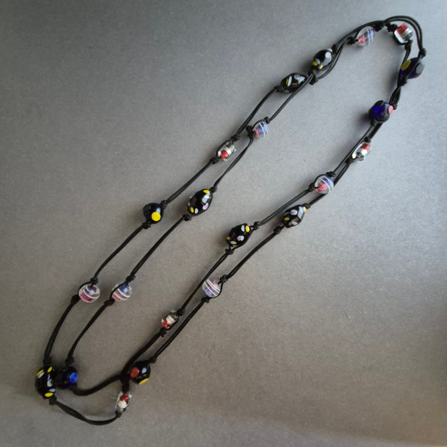 Zweireihige Kette mit bunten Glasperlen auf schwarzem Band