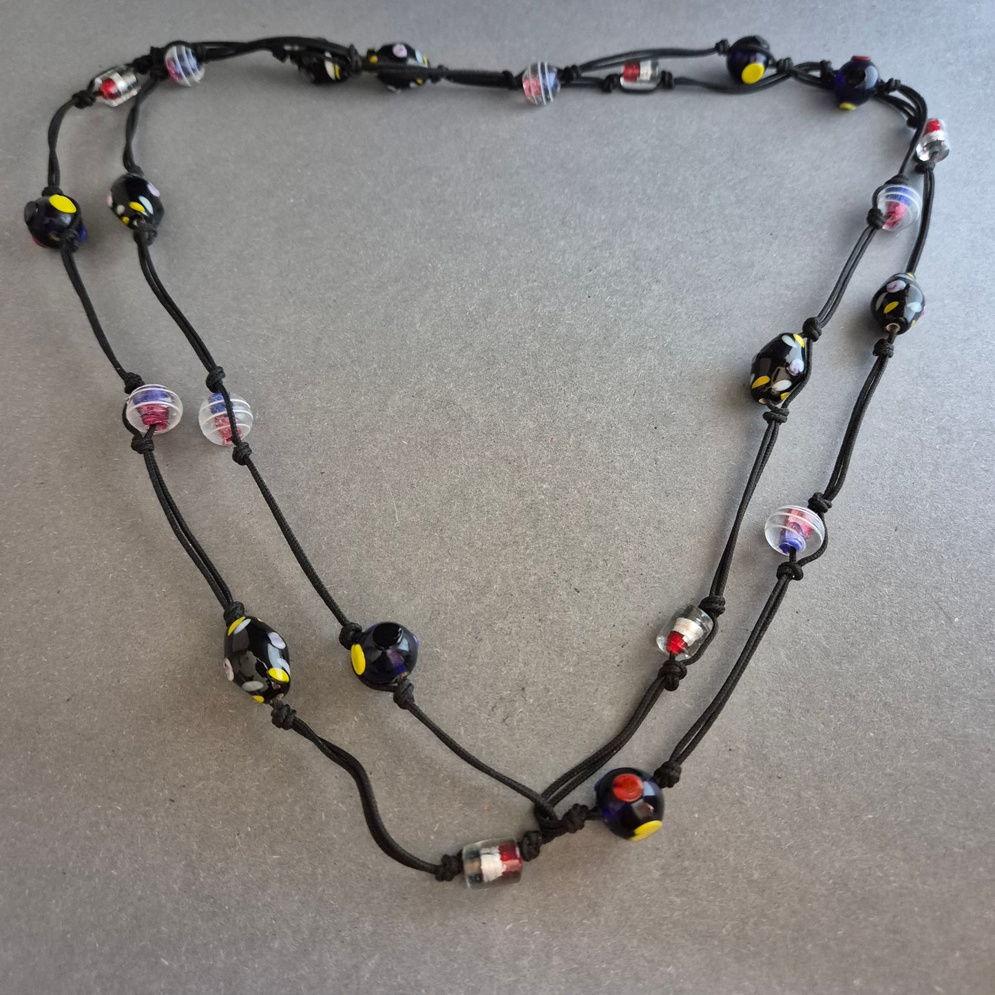 Zweireihige Kette mit bunten Glasperlen auf schwarzem Band