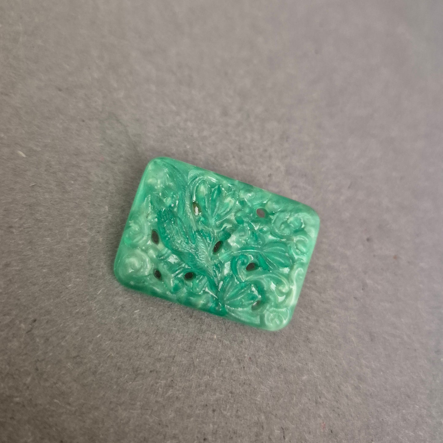 Asiatisch inspirierte Brosche mit floraler Reliefarbeit in Jade-Optik