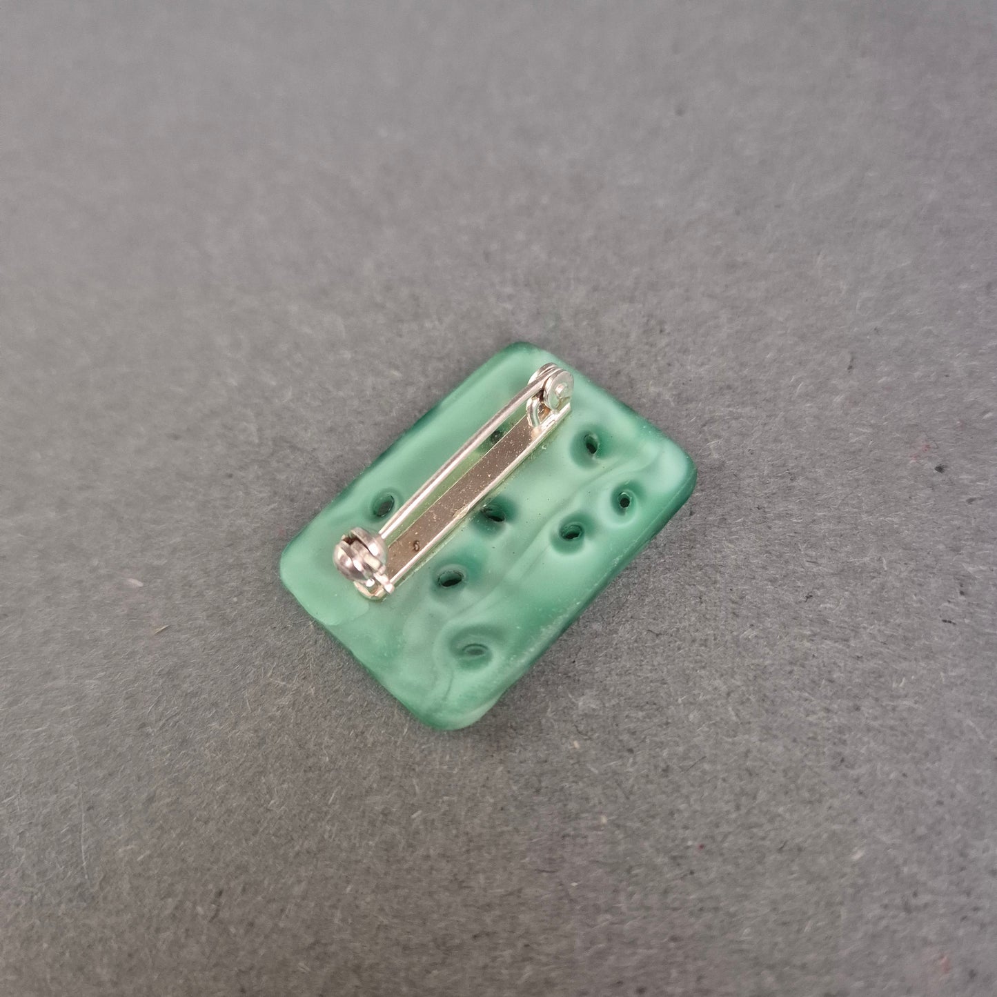 Asiatisch inspirierte Brosche mit floraler Reliefarbeit in Jade-Optik