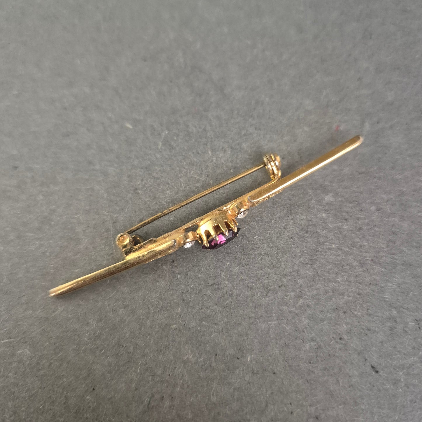 Antike Goldbrosche mit violettem Stein und Strassakzenten