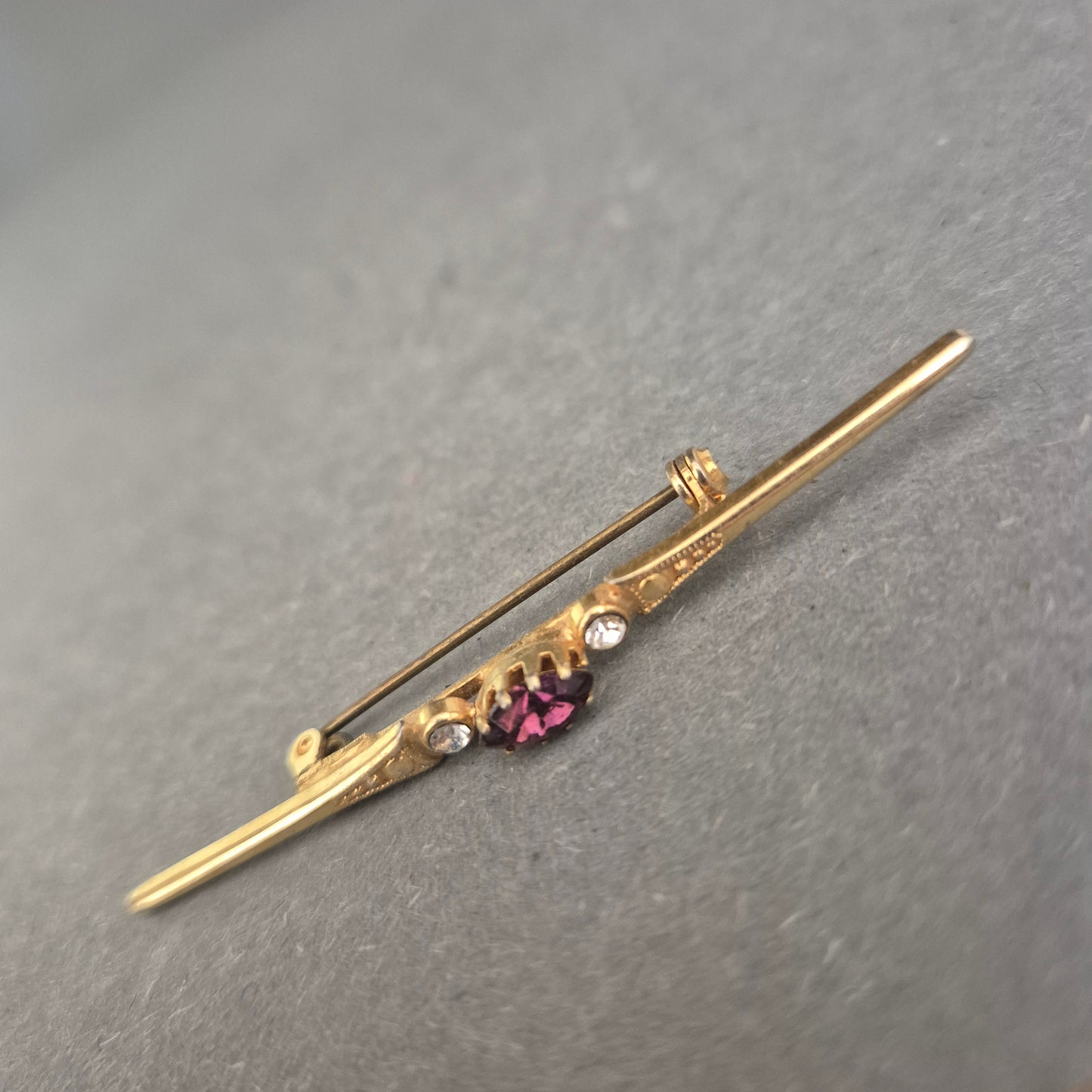 Antike Goldbrosche mit violettem Stein und Strassakzenten