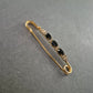 Elegante goldene Brosche – Sicherheitsnadel mit schwarzen Ziersteinen