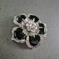 Brosche in Blütenform mit Strass und schwarzer Emaille – Glamourös